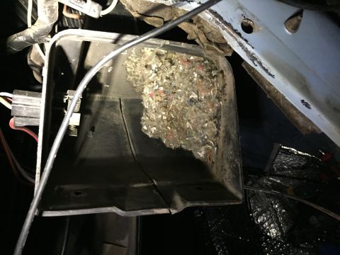 1978 Ford Bronco - The blower housing is filled with a large amount of debris and insulation, likely obstructing airflow.