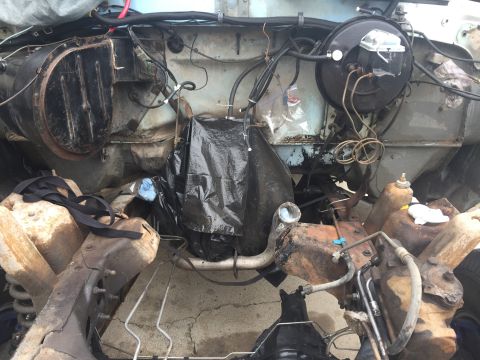 1978 Ford Bronco - Close-up view of the engine bay, showing various components and wiring, some covered for protection.