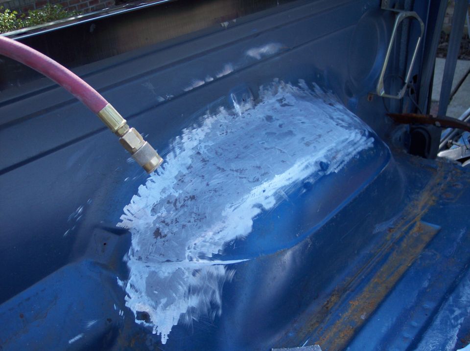Blue body panel with sandblasting in progress