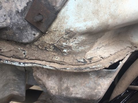 1978 Ford Bronco - Undercarriage view of heavily corroded metal components, showing significant rust and damage.