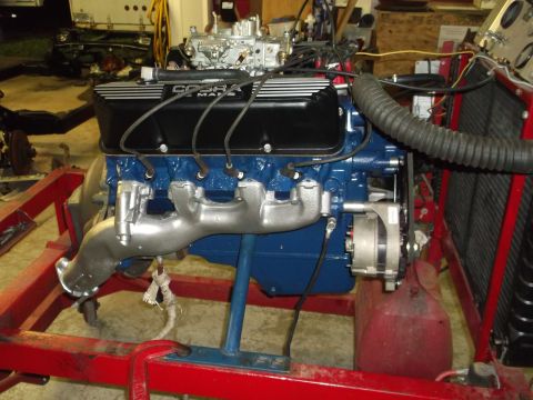 1969 Ford Mustang - A V8 engine, possibly a Ford Cobra, is mounted on a stand with a carburetor and exhaust manifolds visible.