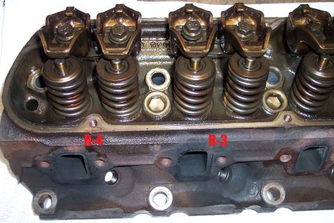 1995 Ford Bronco - Close-up view of an engine cylinder head, showing rocker arms, valve springs, and intake/exhaust ports. Markings B-4 and B-3 are visible.