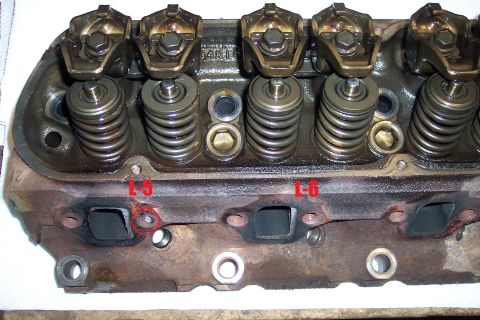 1995 Ford Bronco - Close-up view of an engine cylinder head, showing valve springs, rockers, and exhaust ports. Markings indicate L-6.