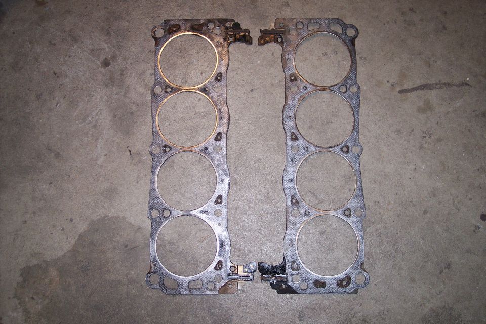 Two engine cylinder head gaskets on a concrete surface