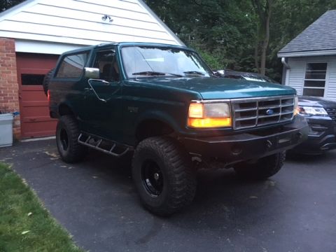 1996 Ford Bronco - Green 1996 Ford Bronco parked in a driveway, an aftermarket bumper and off-road tires.