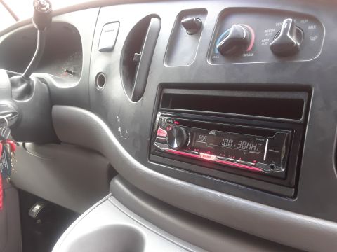 1999 Ford E250 - The interior of a van shows the dashboard with a JVC stereo and climate controls.