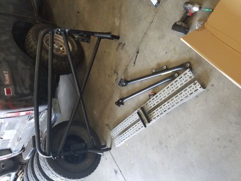 1984 Land Rover Defender - Roll cage and suspension parts are on the floor next to a Scout II vehicle.