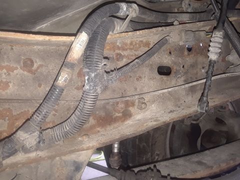1996 Ford F-350 - Underbody view of a truck frame showing wiring harnesses and connectors, with visible rust.