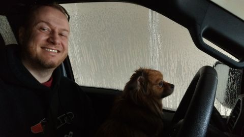 2006 Mitsubishi Evolution - A man and his dog are inside a vehicle, with water streaks visible on the window.