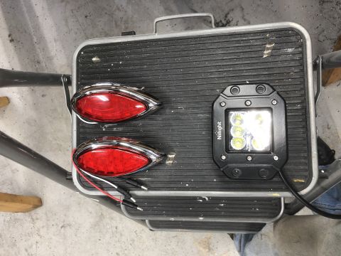 1992 Jeep Wrangler - Two red oval tail lights and a square LED light bar are displayed on a textured surface.