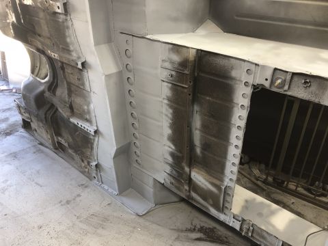 1992 Jeep Wrangler - The underside of a vehicle, likely undergoing restoration or repair, shows exposed metal and suspension parts.