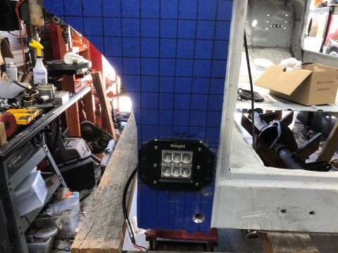 1992 Jeep Wrangler - A Nilight LED light bar is attached to a blue grid-covered panel, likely during a vehicle modification or repair process.