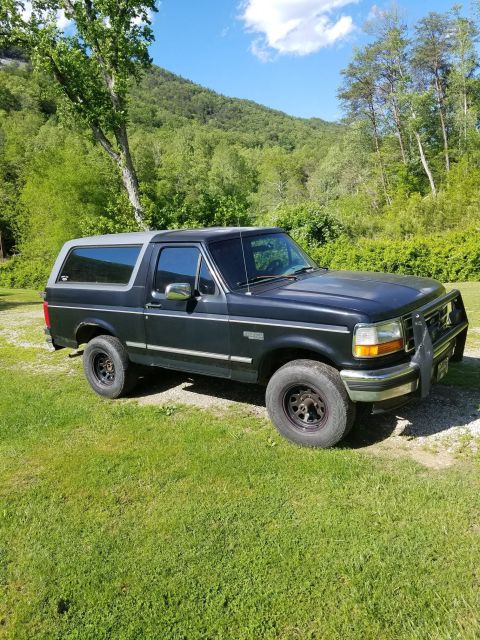 1996 Ford Bronco - This 1996 Ford Bronco XLT is parked outdoors with a scenic mountain backdrop.