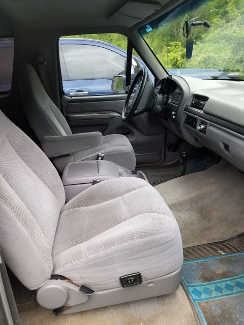 1996 Ford Bronco - The interior of a 1992 Ford Bronco shows cloth seats and a dashboard, with another vehicle visible outside.