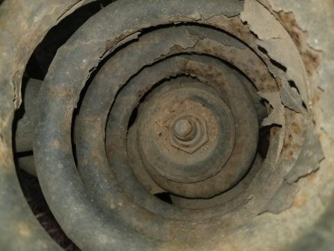 1996 Ford Bronco - Rusted suspension coil spring, showing significant wear and corrosion on the metal.