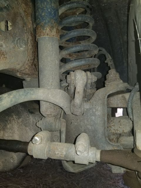 1996 Ford Bronco - This image shows the suspension system of a vehicle, focusing on the shock absorber and coil spring assembly.