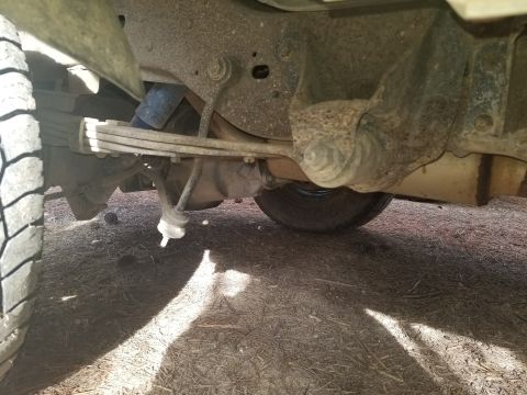 1996 Ford Bronco - Undercarriage view of a vehicle's rear suspension system.