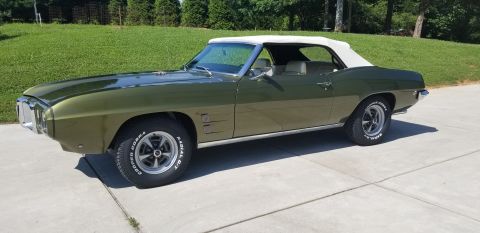 1969 Pontiac Firebird - Green 1969 Pontiac Firebird convertible with a white soft top is shown from a three-quarter front angle.