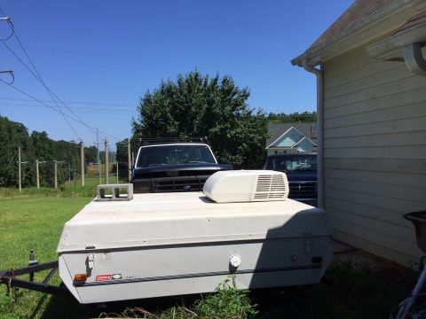 1996 Ford Bronco - A black 1992 Ford F-Series truck is parked next to a house, partially obscured by a pop-up camper.
