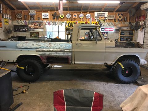 1967 Ford F-250 - This 1967 Ford F-250 pickup is in a garage, showing signs of repair and modification with its large tires.