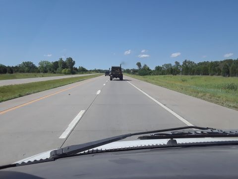 1994 Ford Bronco - Two trucks are seen driving on a highway on a sunny day.