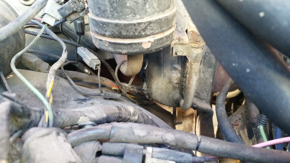 Engine bay with wiring harnesses and cylindrical components visible