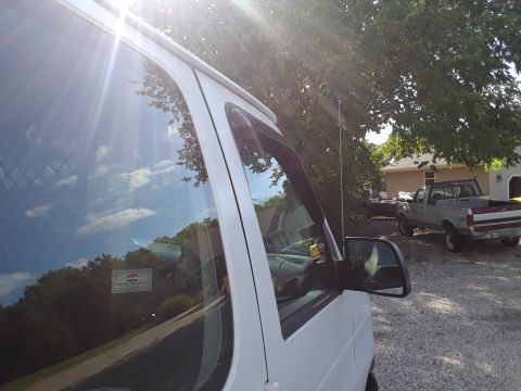 1999 Ford E250 - A white van is parked outdoors, with a second truck visible in the background.