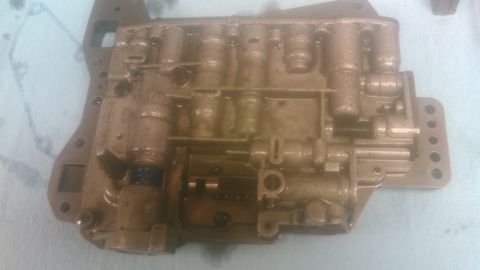 1992 Ford Bronco - An automatic transmission valve body removed from the vehicle and laid face-up on a light marble countertop, its cast aluminum casting stai…
