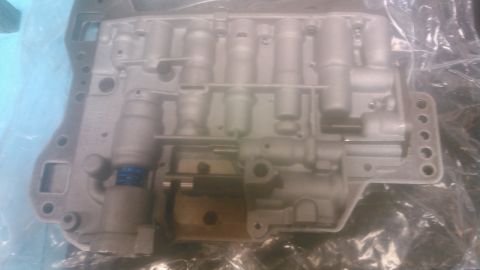 1992 Ford Bronco - A clean, freshly rebuilt automatic transmission valve body sitting on a plastic bag, its bare aluminum casting bright with no fluid stainin…