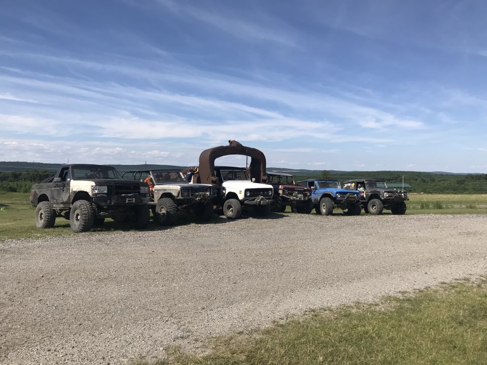 Line of off-road vehicles parked on gravel under a blue sky
