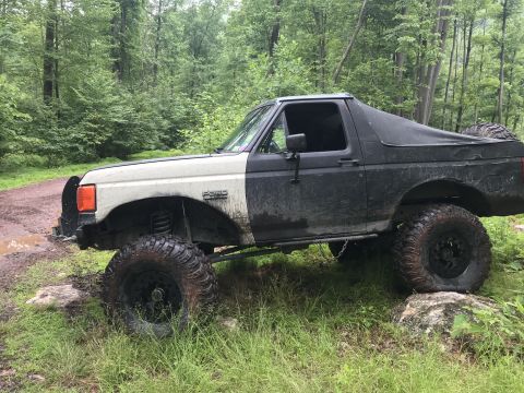 1989 Ford Bronco - Modified 1989 Ford Bronco with large tires and lifted suspension is shown off-road.