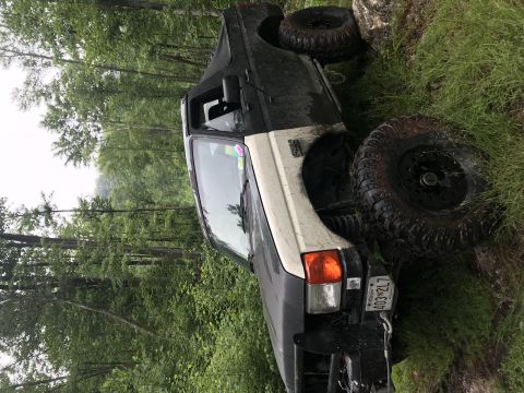 1989 Ford Bronco - This off-road SUV is navigating a challenging, uneven terrain with large tires and a tilted body.