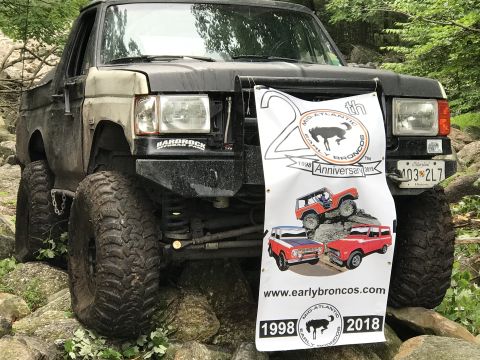 1989 Ford Bronco - This heavily modified Ford Bronco is shown off-road with a banner celebrating an anniversary.