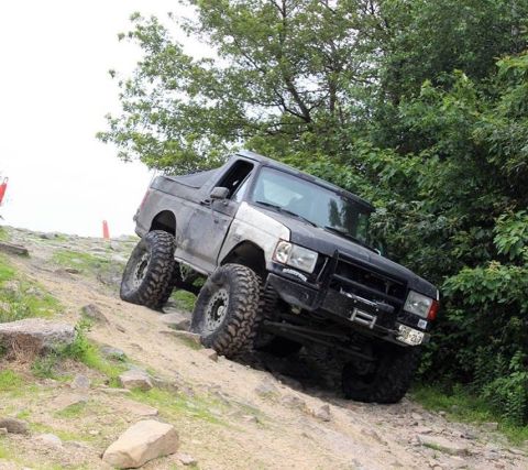 1989 Ford Bronco - Modified 1989 Ford Bronco tackling a challenging off-road trail.