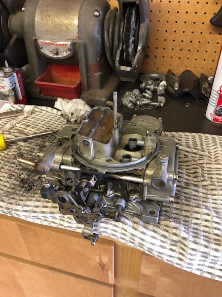 1981 Ford Bronco - Carburetor sits on a cloth next to a Craftsman grinder and various hardware.
