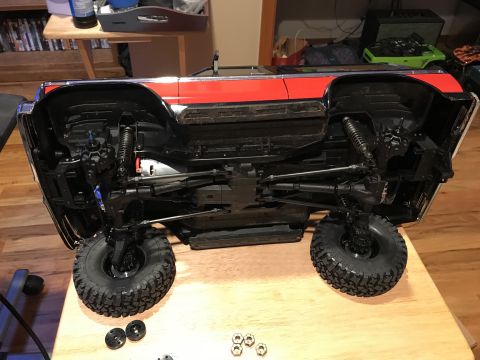1989 Ford Bronco - Underside view of a red and black remote control car chassis with visible suspension and drivetrain components.