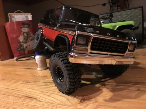 1989 Ford Bronco - A detailed toy model of a Ford Bronco sits on a wooden floor, with a festive shopping bag in the background.