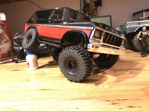 1989 Ford Bronco - A toy truck with a prominent chrome grille and off-road tires is displayed on a wooden surface.
