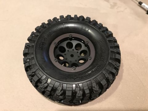 1989 Ford Bronco - A close-up view of a Pit Bull Rock Beast tire mounted on a black wheel with a brown beadlock ring.