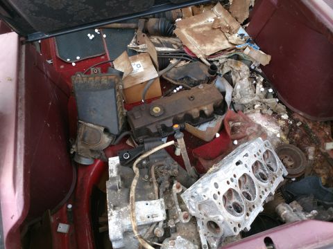 1989 Ford Probe — Engine parts piled in the trunk of a car.