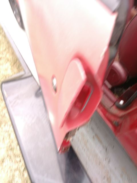 1989 Ford Probe — Blurry interior shot of a red car door panel and handle.