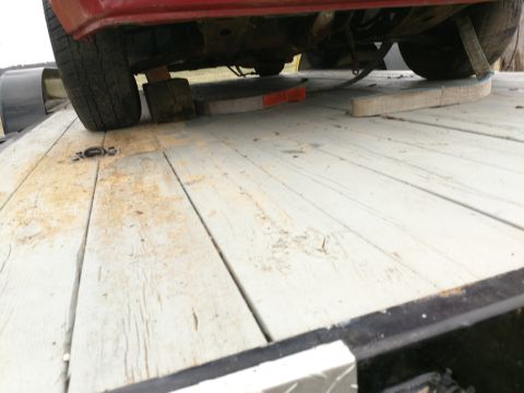 1989 Ford Probe — Rear wheel of red vehicle on wooden blocks on trailer deck