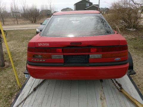 Rear view of a red 1989 Ford Probe on a trailer.