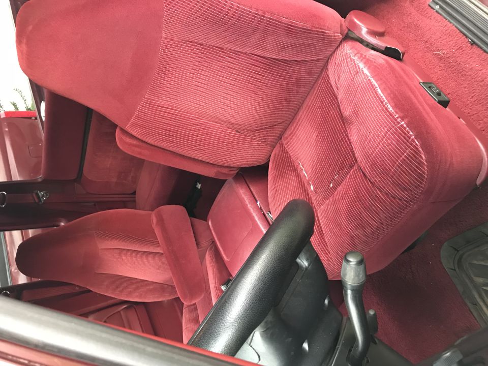 Interior of a red Ford F-150 pickup truck showing front seats and dashboard.