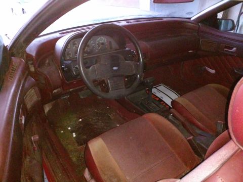 Interior of a 1989 Ford Probe with maroon seats and dashboard.