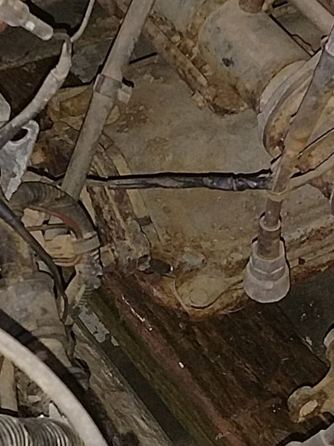 1989 Ford Probe — Close-up of rusted vehicle underside with spliced black wire and electrical tape.