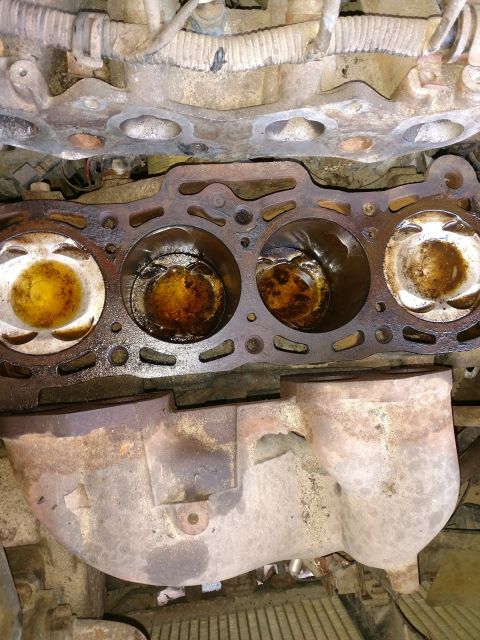 1989 Ford Probe — Engine block with cylinder head removed, showing pistons and exhaust manifold.