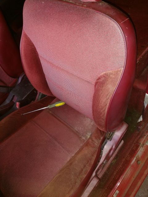1989 Ford Probe — Red car seat with a screwdriver on it.