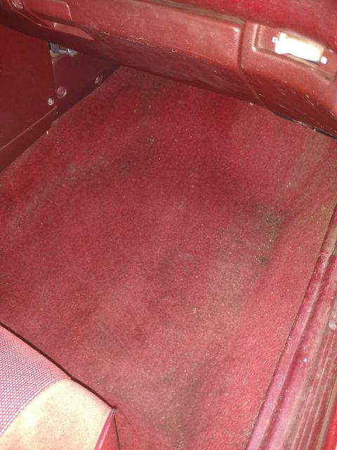 1989 Ford Probe — Red carpeted interior floor of a vehicle with lower dashboard visible.