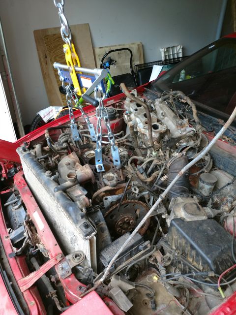 1989 Ford Probe — Red car engine bay with engine hoist and chains attached.